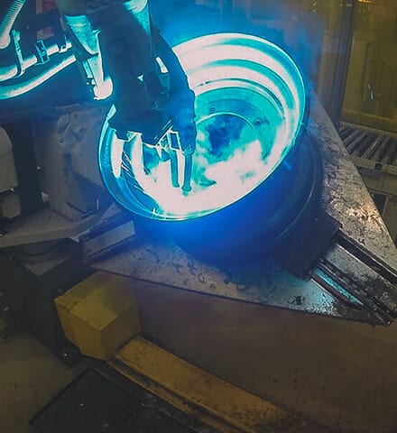 Schweißroboter bei GKN Wheels neben einem Manipulator mit Felge